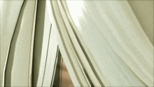 a close up of a white curtain with a light shining through it