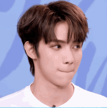 a close up of a person 's face with a blue background behind them