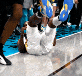 a basketball player is laying on the floor with his feet up