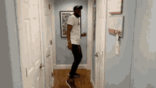 a man is dancing in a hallway in front of a picture on the wall .