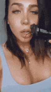 a woman is holding a gun in her mouth and smoking a cigarette .