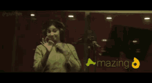 a woman wearing headphones is standing in front of a microphone and the words amazing are on the bottom