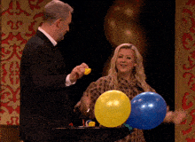 a man and a woman are playing with balloons