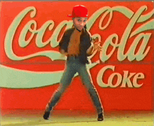 a man dancing in front of a coca cola sign