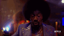 a man in a purple suit is dancing with a netflix logo behind him