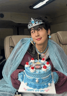 a man wearing a tiara and veil is holding a cake that says happy 2nd day