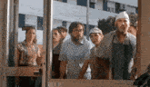 a group of people are standing in front of a door that has a sign on it that says " closed "