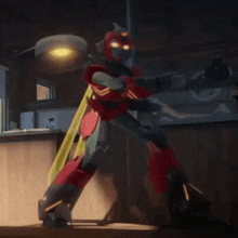 a red robot with a yellow cape is standing in a room .