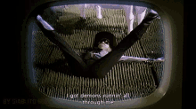a tv screen shows a man laying on the ground with the words i got demons runnin ' all through me