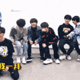 a group of young men are sitting on chairs and kneeling down .