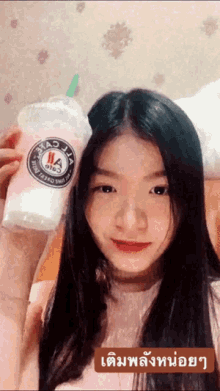 a girl is holding a cup with a logo on it that says ' jl ' on it