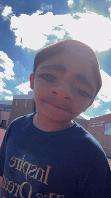 a young boy wearing a shirt that says ' efficient ' on it looks at the camera
