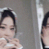 a woman is looking at herself in the mirror while wearing a scarf around her head .