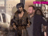 a man in a black and gold outfit is standing in front of a store called orneys work