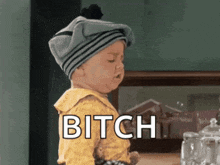 a baby wearing a gray hat says bitch