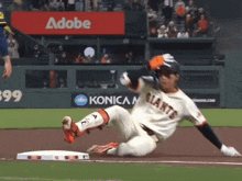 a giants baseball player is sliding into second base