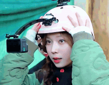 a girl is wearing a pink helmet with a camera attached to it