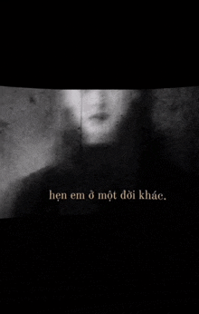 a black and white photo of a person 's face with the words `` hen em o mot doi khach '' in the corner .
