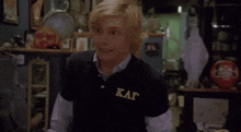 a young man wearing a black shirt with the letters kat on it