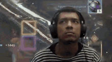 a man wearing headphones looks up at a screen with a number 5 on it
