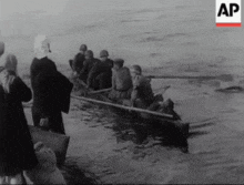 a black and white photo of a group of people in a boat with the letters ap on the bottom right