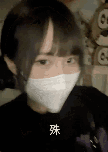 a girl wearing a white face mask with chinese writing on the bottom