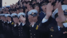 a large group of military men are standing in a line with their hands up in the air .