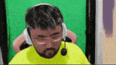a man with a beard is wearing headphones and a microphone .