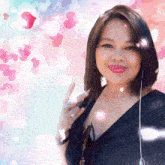 a woman in a black shirt is giving a thumbs up with hearts in the background