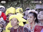 a group of people are posing for a picture and one of them is wearing a yellow hat