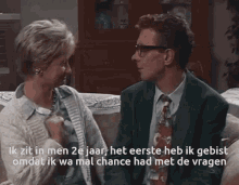 a man and a woman are sitting on a couch with a caption that says ik zit in men 2e jaar
