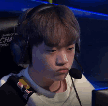 a young boy wearing headphones and a red bull sweatshirt