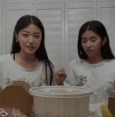 two women are sitting next to each other and one of them has a sticker on her shirt that says ' a ' on it