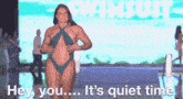 a woman in a swimsuit is walking down a runway at a fashion show .