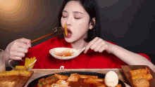 a woman is eating food with chopsticks and a spoon .