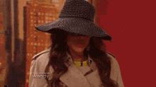 a woman wearing a hat and a trench coat with the word wendy on the bottom