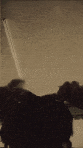 a blurry picture of a person standing in a room with a light on the ceiling