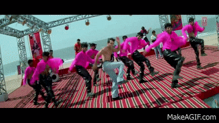 a group of men in pink shirts are dancing on a red and black striped rug