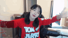 a girl wearing a red shirt that says tom jerry