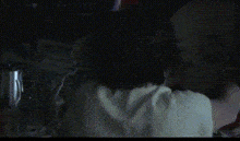 a close up of a woman 's face in a dark room with a blurred background .
