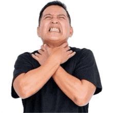 a man in a black shirt has his hands on his neck