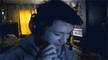 a man wearing headphones is smoking a cigarette in a dark room .