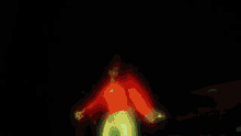 a man in a red hoodie is standing on the hood of a green car .