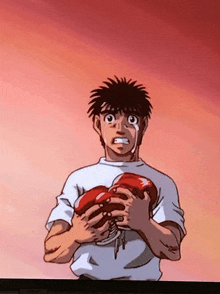 a man in a white shirt is crying while holding two red boxing gloves in his hands