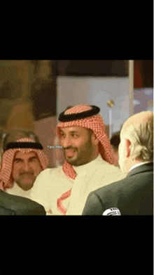 a man in a turban is smiling in a group of people