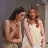 two women are standing next to each other and one of them is wearing a watch