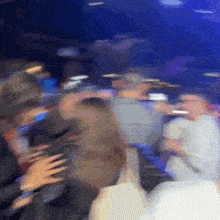 a blurry picture of a crowd of people dancing in a dark room