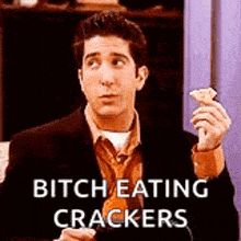 a man in a suit and tie is holding a cracker and says `` bitch eating crackers '' .