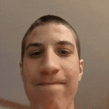 a young man with a shaved head looks at the camera with his mouth open