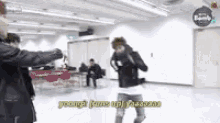 a group of people are standing in a room and one of them is holding a gun .